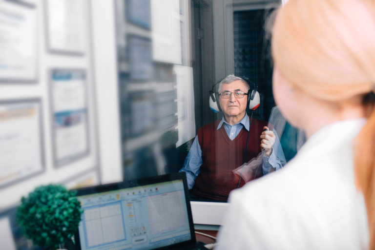 senior patient having hearing exam