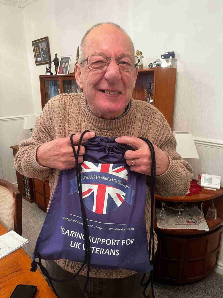 Photo of Mr. Wooldridge holding a bag and smiling brightly.