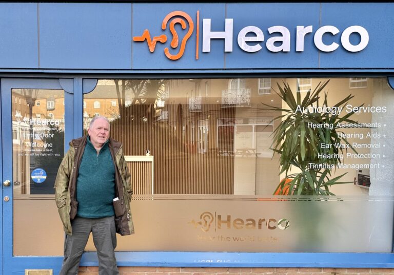 Mr Oliver St John in front of Hear Co Clinic getting his hearing back.
