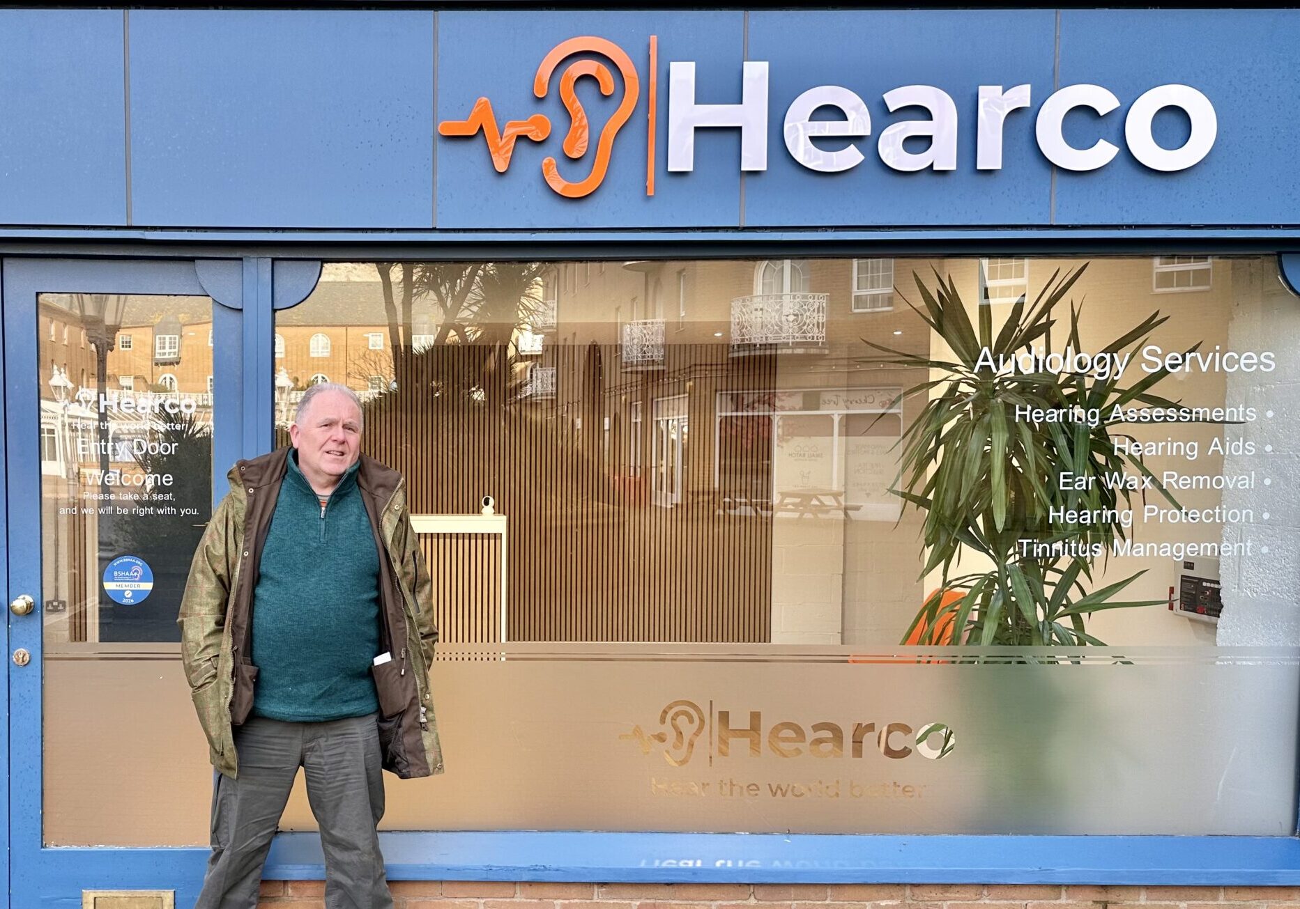 Mr Oliver St John in front of Hear Co Clinic getting his hearing back.