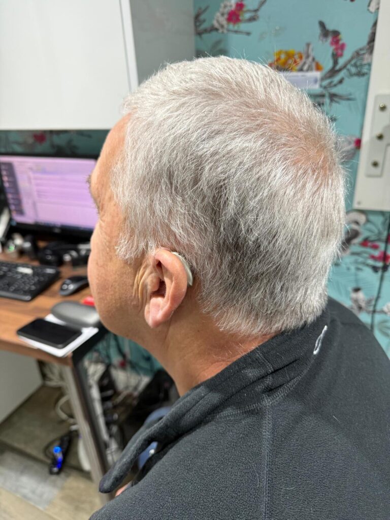 Mr Pinnegar with his near hearing aids at Hear4U Rothwell Clinic.